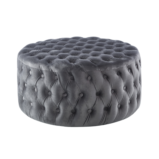 Luxurious grey velvet round ottoman in a homely setting