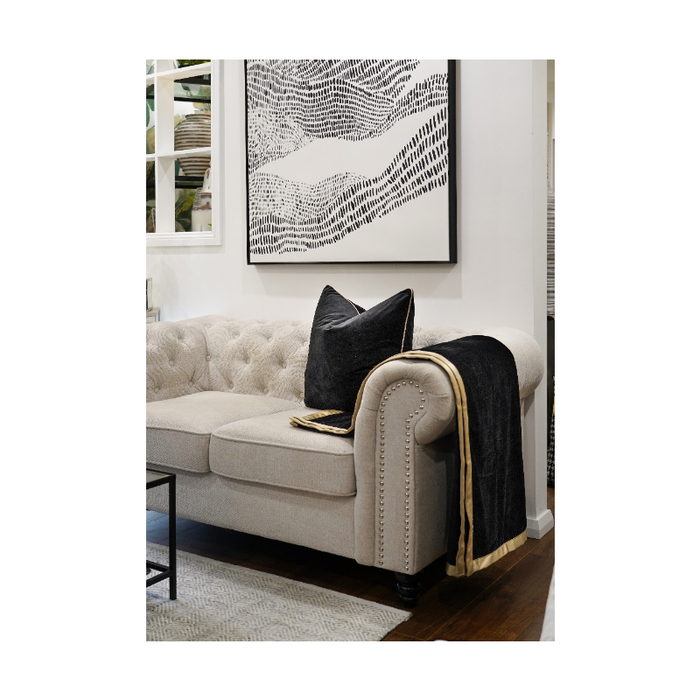 Gold Trim Double Sided Pipping Throw elegantly draped over a sofa