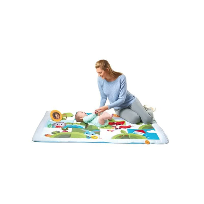 Infant joyfully playing on the colourful Tiny Love Meadow Days Super Mat filled with engaging activities