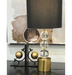 The Windsor Lamp's white shade casts a warm, inviting glow in a chic living space.