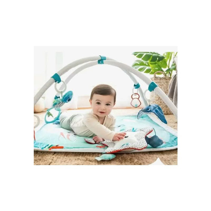 Baby joyfully interacting with the colorful, ocean-themed activities on the Tiny Love Gymini