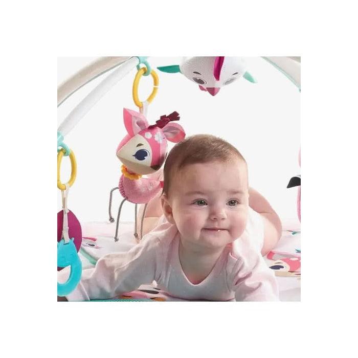 Joyful infant girl reaching out to the textured toys on her Tiny Princess Tales playmat