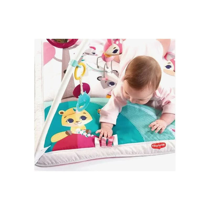 Joyful infant girl reaching out to the textured toys on her Tiny Princess Tales playmat