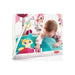 Joyful infant girl reaching out to the textured toys on her Tiny Princess Tales playmat