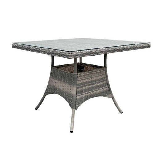 Close-up of the Serenity Wicker Oasis table's tempered glass top, shimmering under open skies